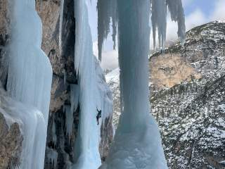 Person klettert an imposanten Eiswasserfällen
