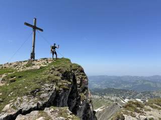 Wanderer am Gipfel mit Blick über bergige Landschaft