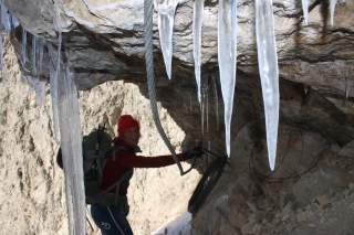 Im Klettersteig auf den Passo delle Farangole hängen Eiszapfen an der Wand.