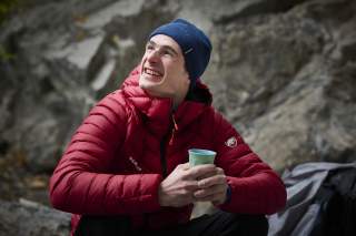 Adam Ondra sitzt an einem Wandfuß
